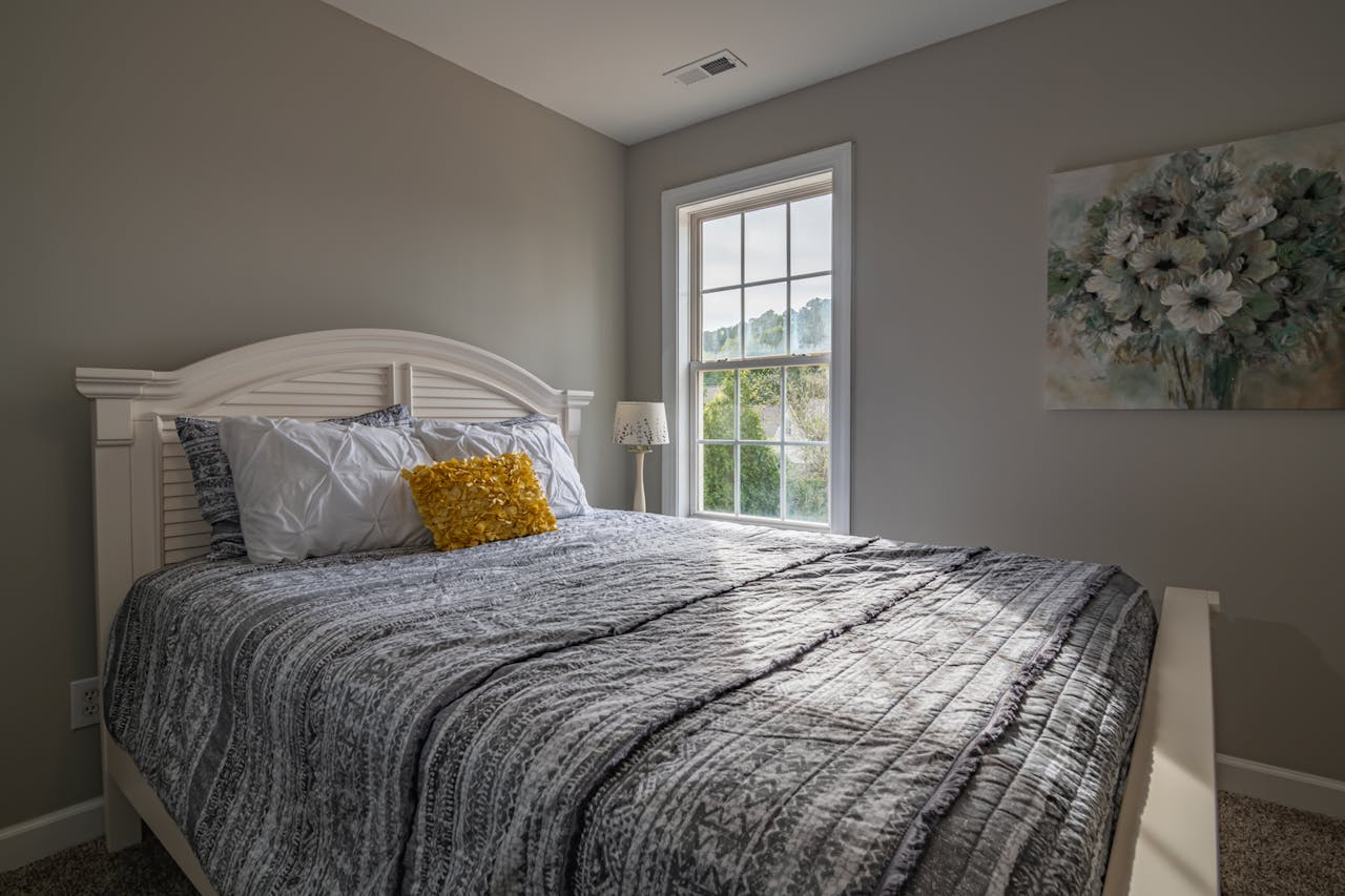 about-02 A warm, inviting bedroom with a double bed and natural light streaming in.