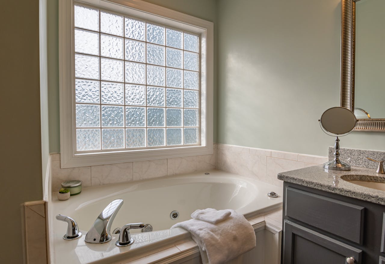about-01 Stylish modern bathroom featuring a luxury bathtub, sleek sink, and large window. Perfect for relaxation.